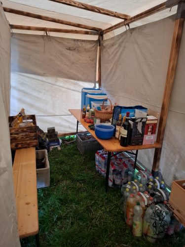 im hinteren Bereich des Küchenzelts eine Fest-Bank mit Tisch ebenfalls mit den Vorräten