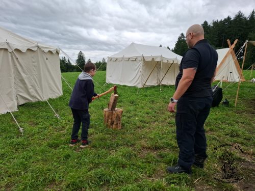 Toni zeigt wie man Holzhackt und überwacht das ganze damit sich kein Kind verletzt