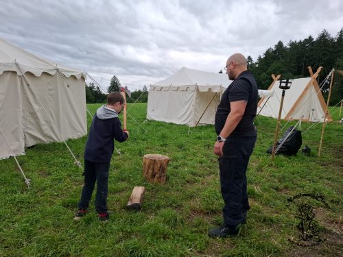 Toni zeigt wie man Holzhackt und überwacht das ganze damit sich kein Kind verletzt