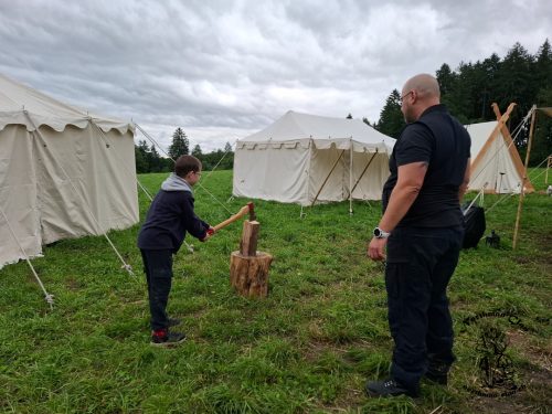 Toni zeigt wie man Holzhackt und überwacht das ganze damit sich kein Kind verletzt