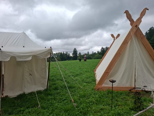 Hinter den Zelten wird in einer Regenpause Schwertkampf geübt